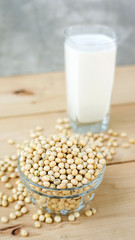 soybean in a bowl and soy milk on a wooden background.