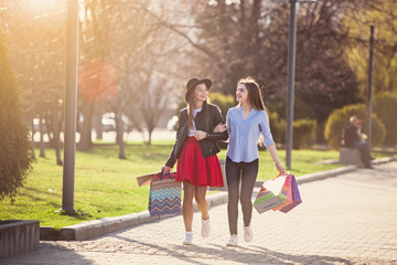 Fototapeta premium Two girls walking with shopping on city streets
