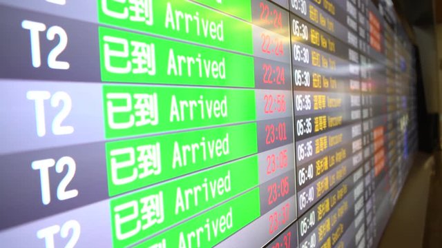 4K International arrivals board displayed on flight schedule in several languages. Waiting room with screen timetable information plane arrived in airport at Taiwan.-Dan