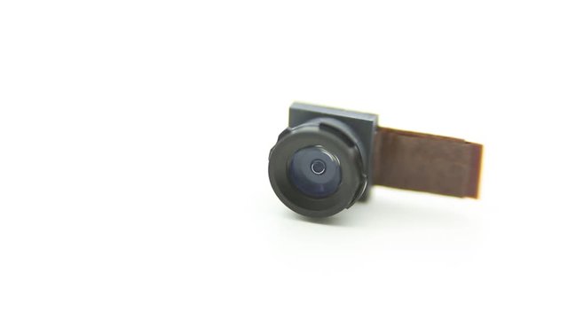Close up on a camera module for mobile phone. Closeup hand of man take the smartphone lens in studio shot with white background -Dan