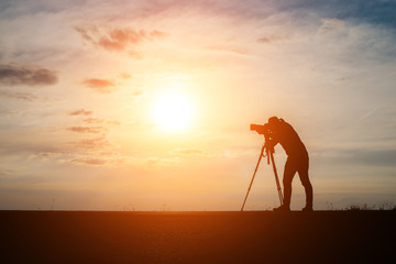 Silhouette of a photographer shoots a sunset.