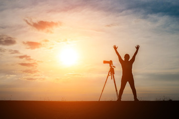 Silhouette of a photographer shoots a sunset.