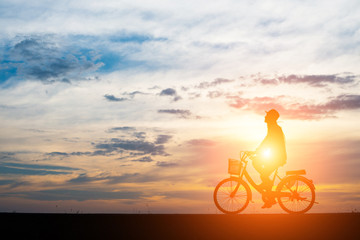 Fototapeta na wymiar Young man ride bicycle on sunset background.