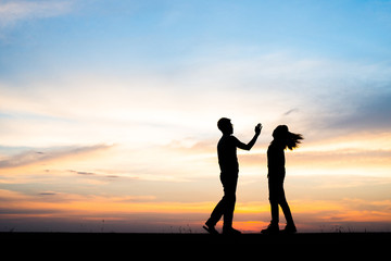 Silhouette of couple upset,man and women are quarrel in sunset time.