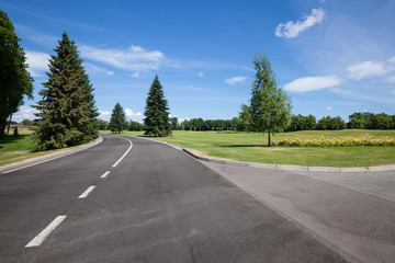 Fototapeta premium Asphalt road at modern city green park