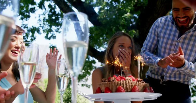 Friends celebrating womans birthday at outdoor restaurant