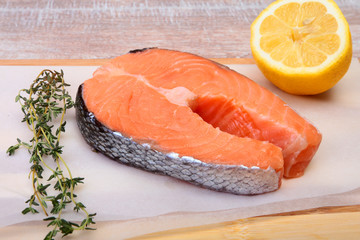 fresh raw salmon with spices and lemon on wooden cutting board. ready for cookin