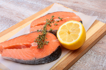 fresh raw salmon with spices and lemon on wooden cutting board. ready for cookin