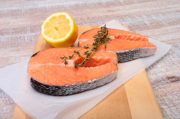fresh raw salmon with spices and lemon on wooden cutting board. ready for cookin