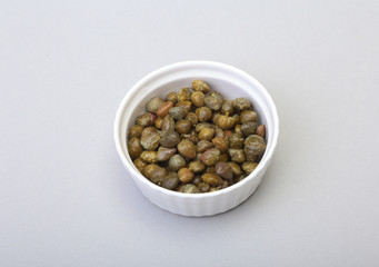 bowl with fresh capers isolated on white background.