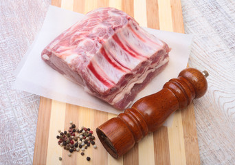 Raw pork chops and spice grinder on cutting board. Ready for cooking.