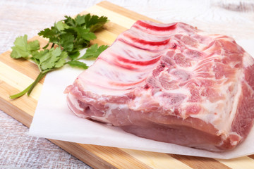 Raw pork chops, spices and basil on cutting board. Ready for cooking.