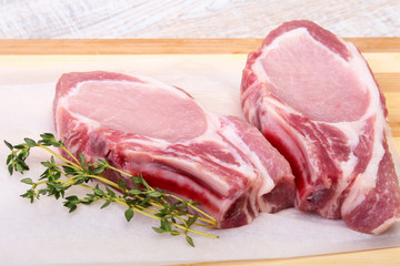 Raw pork chops, spices and rosemary on cutting board. Ready for cooking.