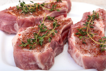 Raw pork chops, spices and rosemary on cutting board. Ready for cooking.