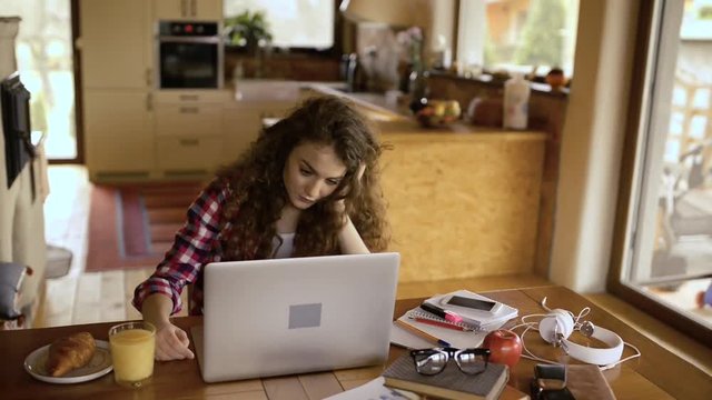 Upset teenage girl at home, working on notebook, studying