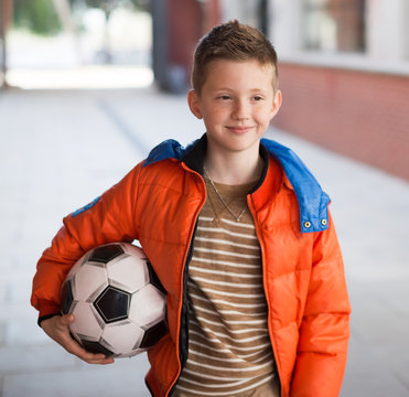 boy in red jacket with soccer Ball