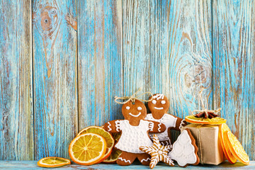 Still life of gingerbread, gingerbread men, dried oranges on blue wooden background, Christmas or New Year background, greeting card template