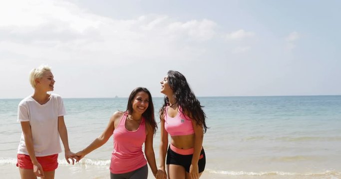 Three Cheerful Girls Walk On Beach Holding Hands, Young Happy Women In Sportwear, Tourist On Vacation Slow Motion 60