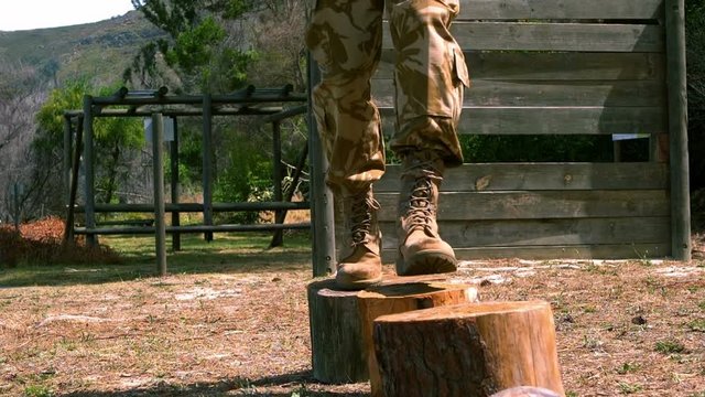Military man walking on cutted tree trunk