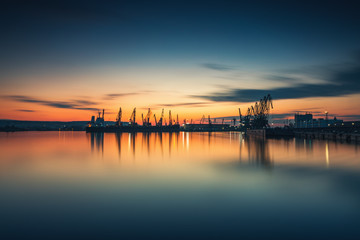 Fototapeta na wymiar Sunset over sea port and industrial cranes, Varna