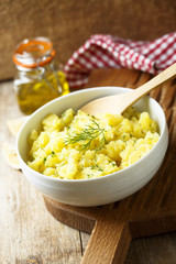 Potato salad with fresh dill in white bowl