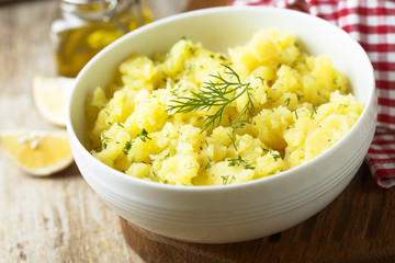 Potato salad with fresh dill in white bowl