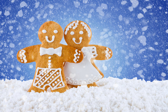 Gingerbread cookies, gingerbread men in the snow on blue background, Christmas or New Year background, template greeting card