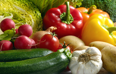 Various kinds of vegetables like zucchini, red radishes, peppers, salad, cabbage, potatoes, garlic 