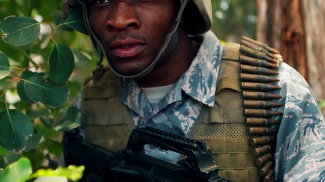 Military man with a gun looking around