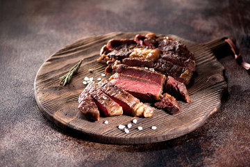 Ribeye steak slices on a wooden serving board