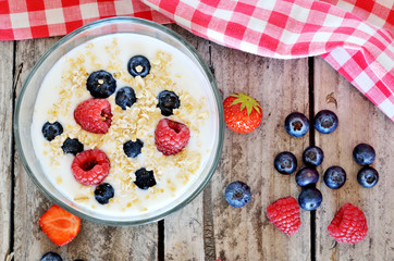 White yogurt in a bowl with oatmeal, blueberries, raspberries and strawberries