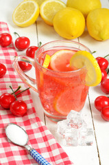 Fruit cherry ice tea with slice of lemon in mug and cherries
