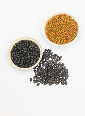 black and green beans in bowl closeup on white background