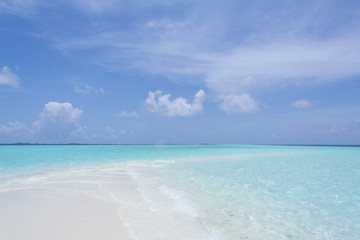 Fototapeta na wymiar Tropical sand beach and blue sky with white clouds