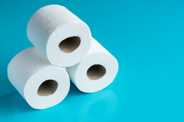 Three rolls of toilet paper in the blue backround.