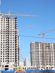 Fototapeta na wymiar Construction of a house in the city. Building construction process, building tower cranes against sky background.