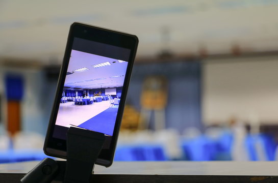 smartphone take a photo on screen of the meeting room business select focus with shallow depth of field.