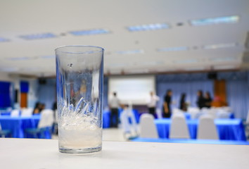 ice water in glass in seminar conference room background. select focus with shallow depth of field