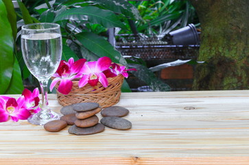 water glass cool select focus with shallow depth of field. with  orchid purple and stone on wooden floor board spa concept