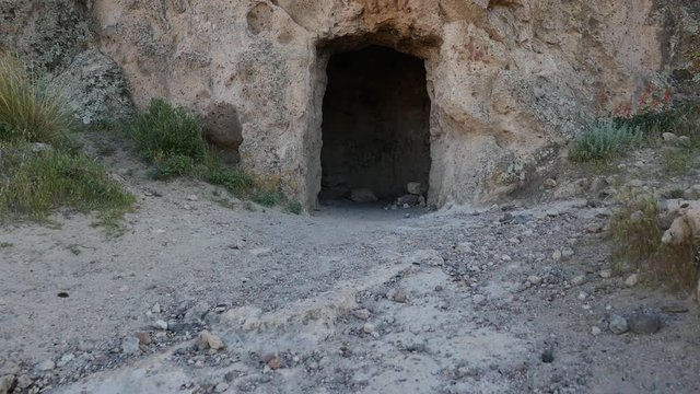 Walking point of view towards the entrance of a mine, cave, or ancient tomb