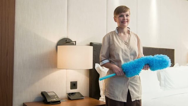 Riant chambermaid holding pp duster