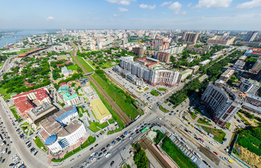 Fototapeta premium Widok miasta z lotu ptaka ze skrzyżowaniami i drogami, domami, budynkami, parkami i parkingami, mostami. Strzał z helikoptera. Obraz panoramiczny.