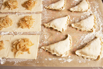 Preparation of pies with cabbage and spices. Layers of puff pastry on a table.