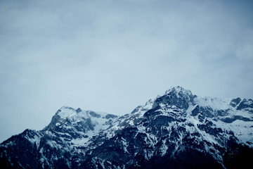 Fototapeta na wymiar Photo depicting a beautiful moody frosty landscape. European alpine mountains with snow peaks on a blue sky background.