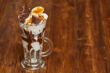 Ice cream chocolate cocktail in glass with syrup and banana