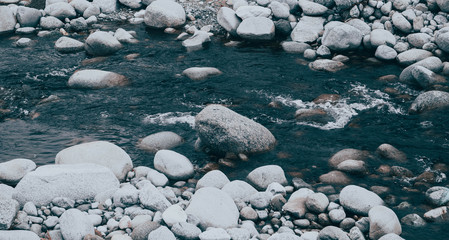 Photo depicting mountain river. Beautiful rapid steam flows between pebbles rocks. Nature of Balkanes, Bulgaria, Bansko city.