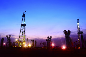 Obraz premium Pumping unit in the work, under the background of the setting sun