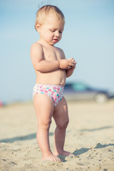 Baby playing with toys on the sandy beach near the sea. Cute little kid in  sand on tropical beach. Ocean coast.