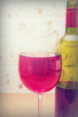 Bottle of red wine with glass ready to pour