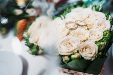 Wedding rings on white wedding bouquet